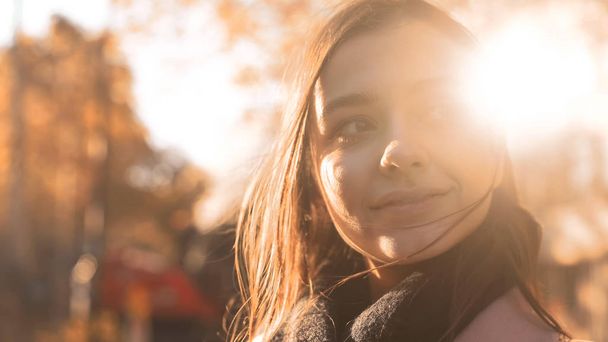 Happy motivated young lady smiling to pleasant autumn sun, feeling inspiration - Фото, зображення