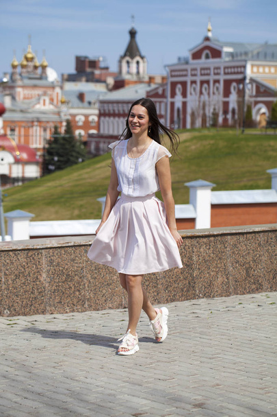 Young brunette woman in pink skirt and white blouse - Foto, imagen