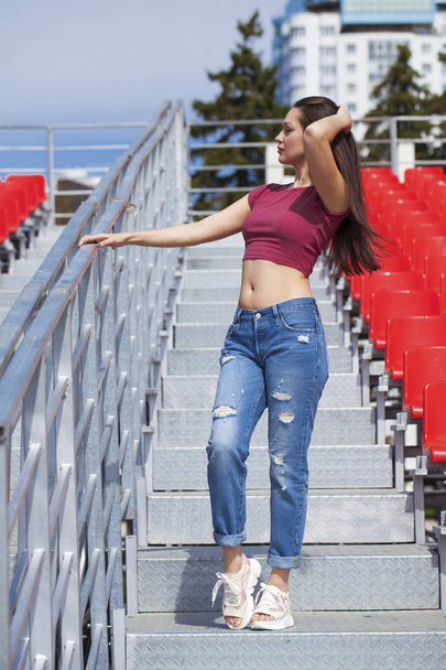 Back view. Portrait of young brunette woman in blue jeans  - Фото, зображення