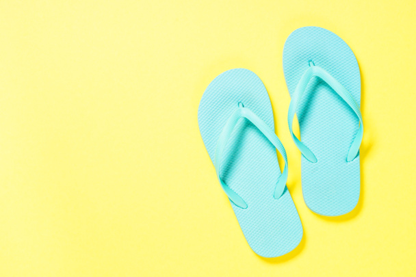 Blue flip flops on yellow background. - Fotó, kép