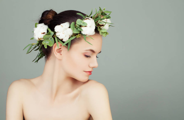 Beautiful young woman with healthy clear skin, green leaves  - 写真・画像