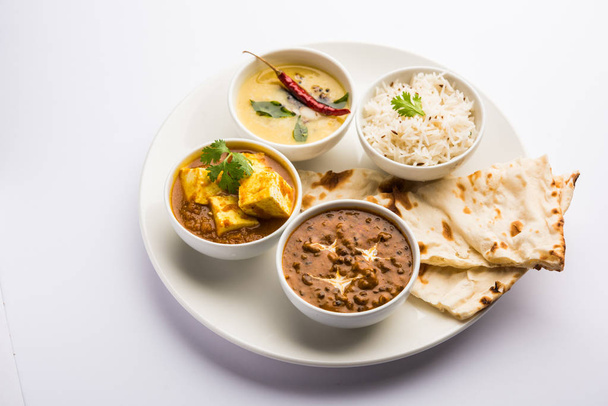 Indyjski wegetariański talerz/Thali o Palak Masala Paneer masła, dal Makhani, płaski chleb lub naan i ryż podawany w białej płycie - Zdjęcie, obraz
