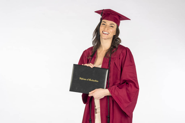 Beautiful Brunette Model Posing With A Diploma After Graduation Against A White Background - Photo, Image