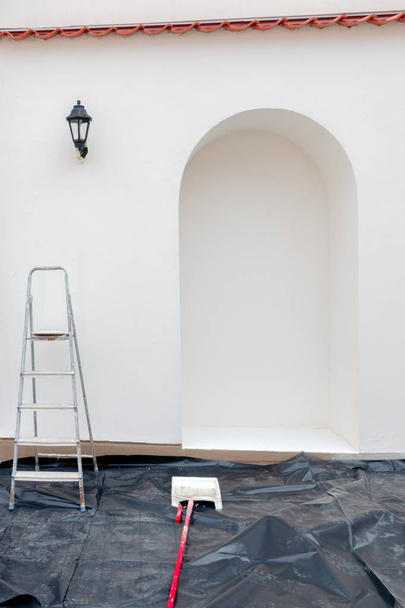 Renovación, restauración, remodelación. Accesorios de pintura frente a la pared exterior vacía de la casa
 - Foto, imagen
