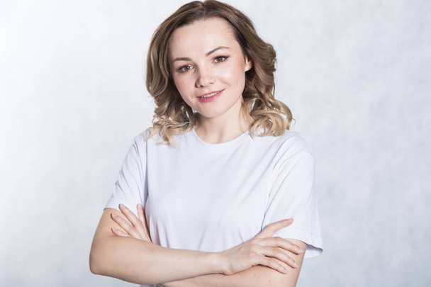 Portrait of a young smiling woman on a white background. - Fotografie, Obrázek