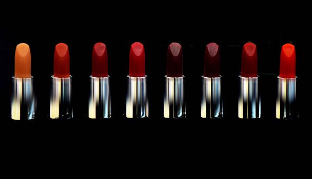 Red lipstick. Cosmetics on black background isolated. Lipsticks on black. High quality lipstick. Daily make up. Cosmetics artistry. Lipstick professional make up. Makeup products. Lip care concept. - Photo, Image