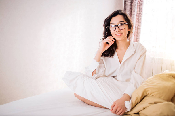 Beautiful Positive woman sitting in bed in morning - Foto, afbeelding