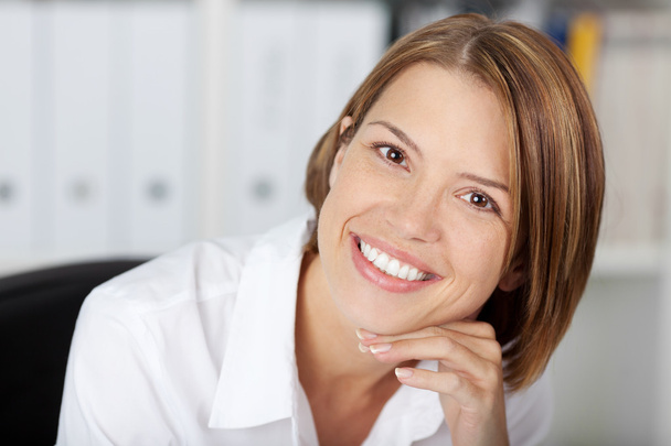 Portrait of a pretty smiling woman at the office - Photo, Image
