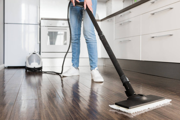 professional home cleaning service. Woman washes the floor with a steam mop - Foto, Bild