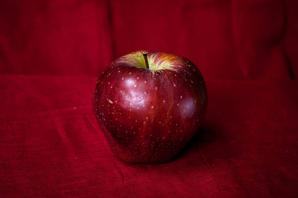 Tiro de arte de uma maçã vermelha em uma baixa vermelha
 - Foto, Imagem