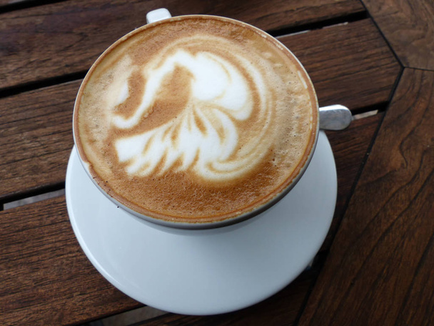 Uma xícara de cappuccino em uma mesa de madeira
 - Foto, Imagem