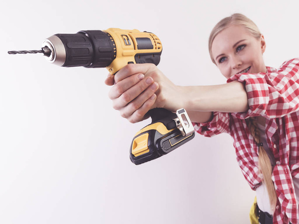 Woman using drill on wall - Photo, Image
