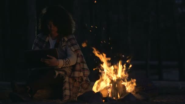 Afro american woman sitting with laptop near the fireplace. Working otside, freelancing. - Footage, Video