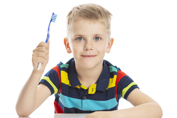 Smiling boy with a toothbrush in his hand. Close-up. Isolated on a white background. - Photo, Image