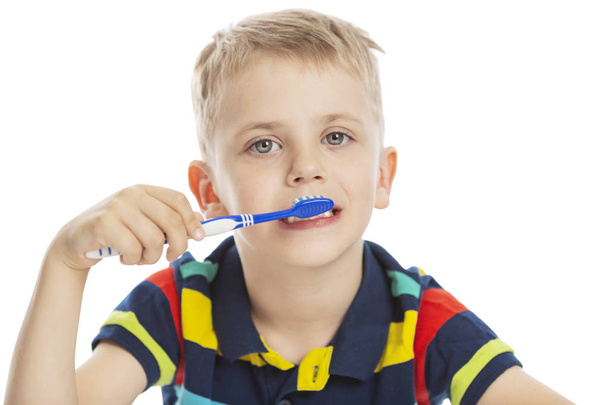 Smiling boy with a toothbrush in his hand. Close-up. Isolated on a white background. - Foto, Bild
