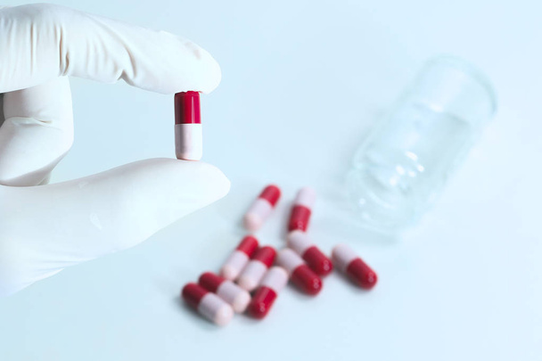 Nurse is hold red and pink antibiotic capsule - Foto, Imagen