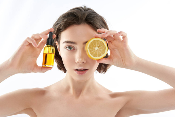 Pretty naked female with lemon and oil bottle - Foto, Bild
