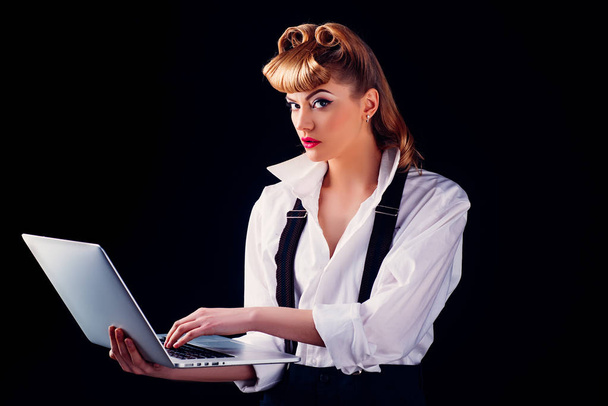 Business woman with a laptop looking at the camera. Beautiful Female Data Analyst Works on a Laptop. Stylish Woman in the Modern Office on black. Young pretty business lady with notebook. - Φωτογραφία, εικόνα