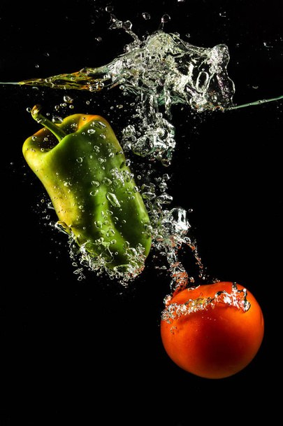Pomidor warzywny i papryka w wodzie Splash na czarno - Zdjęcie, obraz