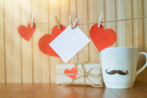 День батьків. Картка для повідомлення з паперовими сердечками, що висять з прищіпки на дерев'яній дошці. День народження. День Святого Валентина - Фото, зображення