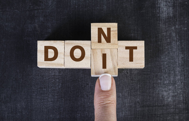 Finger pushing cubes, changing the word "don't" to "do it" - Fotoğraf, Görsel