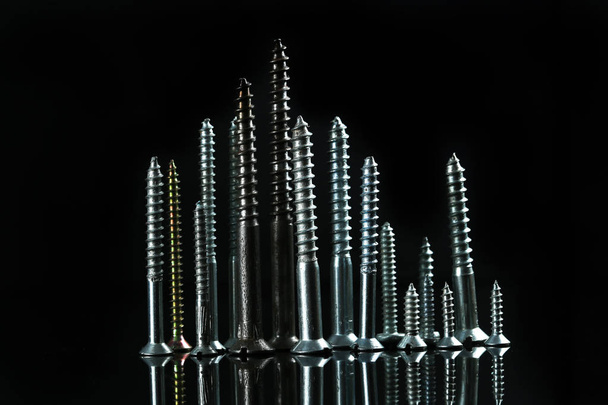 Various screws with reflection on black - Фото, изображение