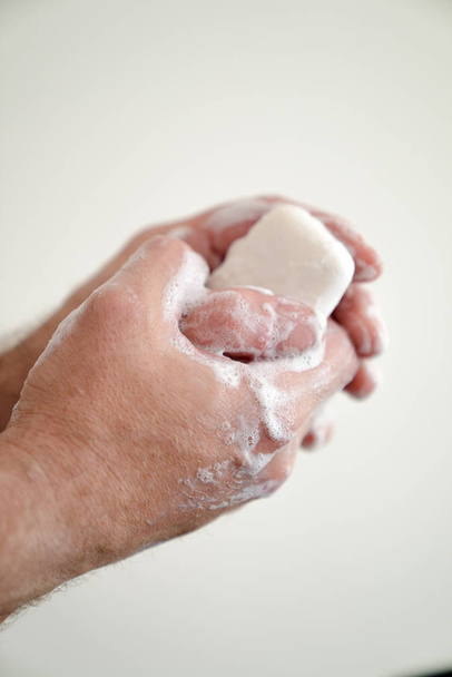 close up de homem lavar as mãos com uma barra de sabão e sabão s
 - Foto, Imagem