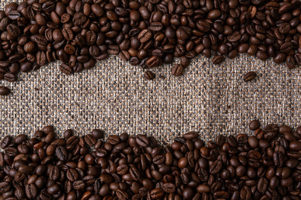 Coffee beans and sackcloth background. Copy Space - Zdjęcie, obraz