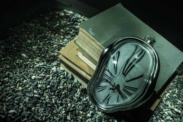 Концепция времени. Искаженные мягкие плавильные часы на старых книгах. На темном туманном фоне. Селективный фокус
 - Фото, изображение
