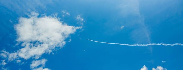 Één sportvliegtuig van Aerobatic team damp Trails in Blue Sky. Vlak witte damp rails sporen achtergrond. Boedapest, Hongarije. - Foto, afbeelding