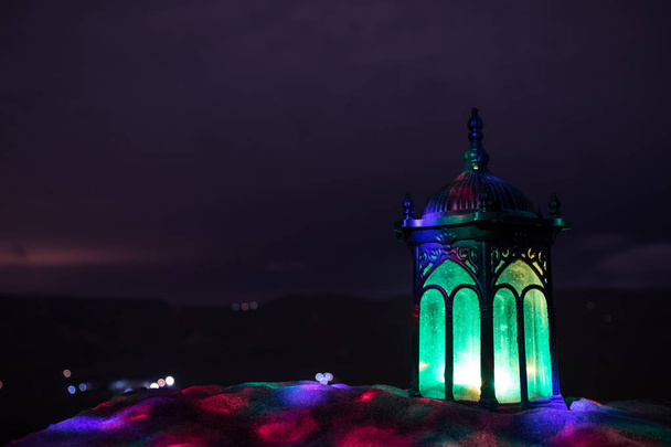 ornamentale arabische Laterne mit brennender Kerze, die in der Nacht leuchtet. Festliche Grußkarte, Einladung zum muslimischen Heiligen Monat Ramadan Kareem. - Foto, Bild