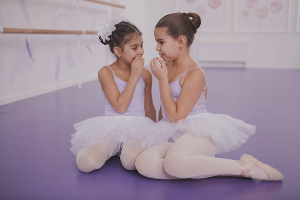 Two little ballerinas talking after dancing lesson - Фото, изображение