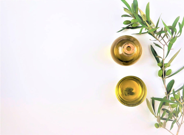 olive oil with a branch of green olives on white background  - Fotó, kép