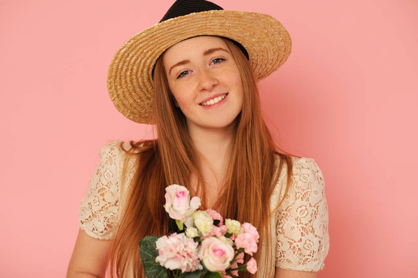 Beautiful, idyllic girl with straw hat and bouquet of flowers. - Foto, afbeelding