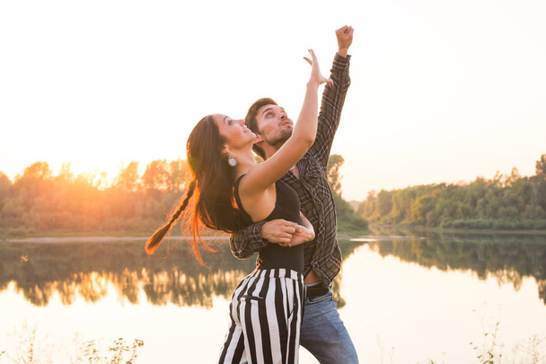 Romântico, dança social e conceito de pessoas - jovem casal dançando um tango ou bachata perto do lago
 - Foto, Imagem