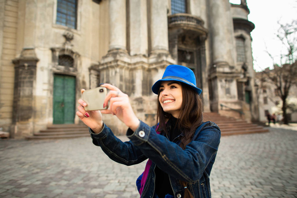 lächelndes junges Mädchen beim Fotografieren der architektonischen Denkmäler der Altstadt lviv. Ukraine - Foto, Bild