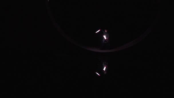 Junge Zirkusartistin im schwarzen Kostüm trickst mit LED-Ausrüstung - poi - Filmmaterial, Video