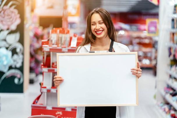 Smiling brunette woman holding white blank board - Foto, Imagem