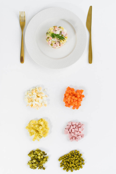 Salada Olivier e ingredientes para cozinhar em um fundo branco
. - Foto, Imagem