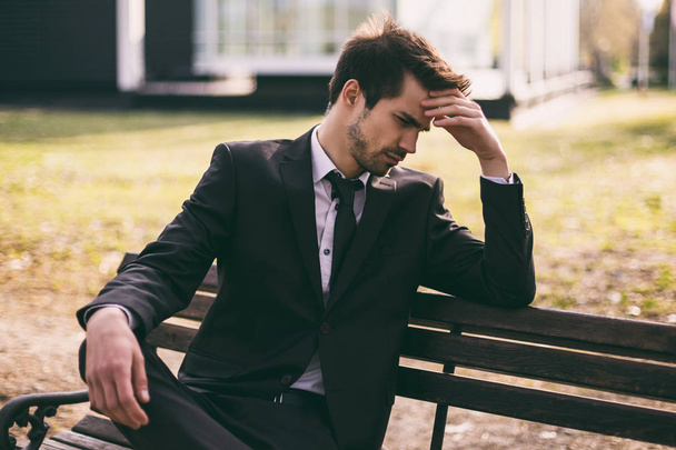 Worried businessman  sitting outdoor.Toned image. - Foto, afbeelding