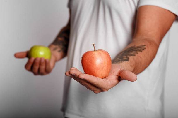 fat man on a white background with an apple in his hands. man chose a healthy lifestyle.  - Foto, imagen