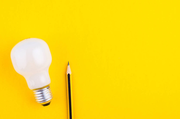 Bleistift und Glühbirne über gelbem Hintergrund für kreative Ideen - Foto, Bild