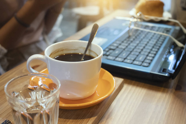 Csésze kávé és laptop a fából készült asztal a kávézóban - Fotó, kép