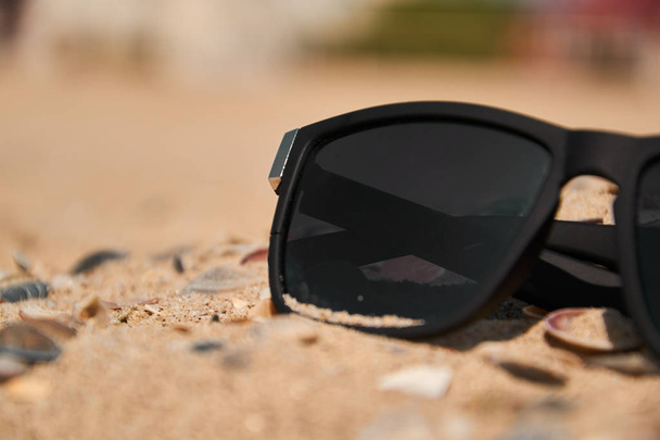 Sunglasses on sandy beach in summer - vintage color styles - Foto, imagen