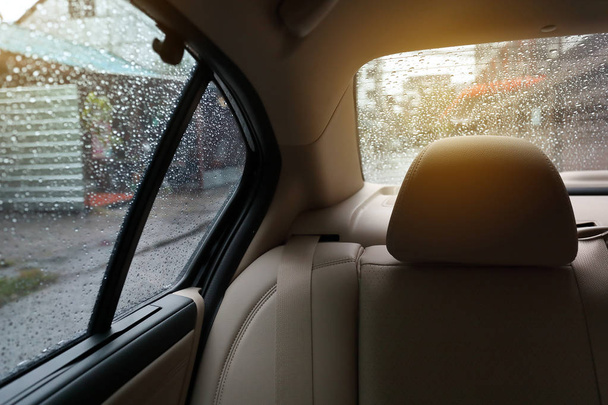 雨で車の中の後部座席をウィンドウにドロップします。 - 写真・画像
