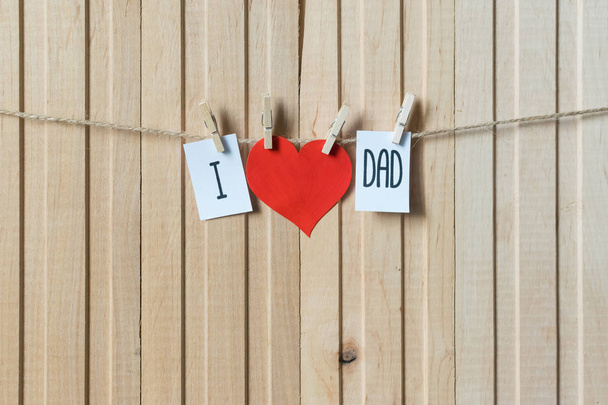 Η ιδέα της μέρας των πατέρων. Μήνυμα με χαρτί καρδιά κρέμεται με καρφίτσες πάνω από ανοιχτόχρωμο ξύλινο σανίδα. Να τα εκατοστήσεις - Φωτογραφία, εικόνα