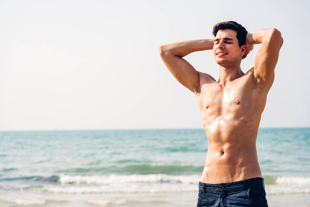 Portrait of smiling handsome sexy man showing muscular fit body  - Photo, Image