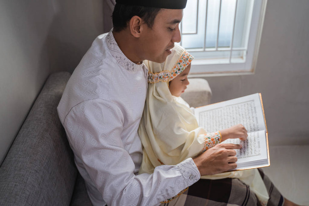 daddy teach her daughter to read quran - 写真・画像