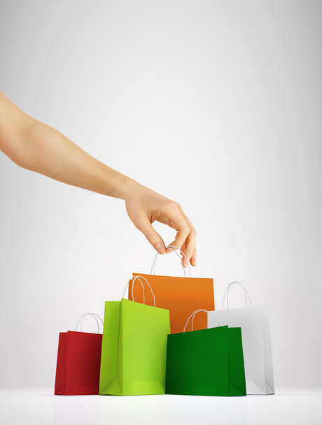Female hand holding colorful shopping bags - Zdjęcie, obraz