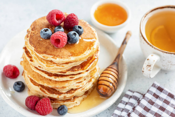 Homemade pancakes topped with berries and honey - Photo, Image